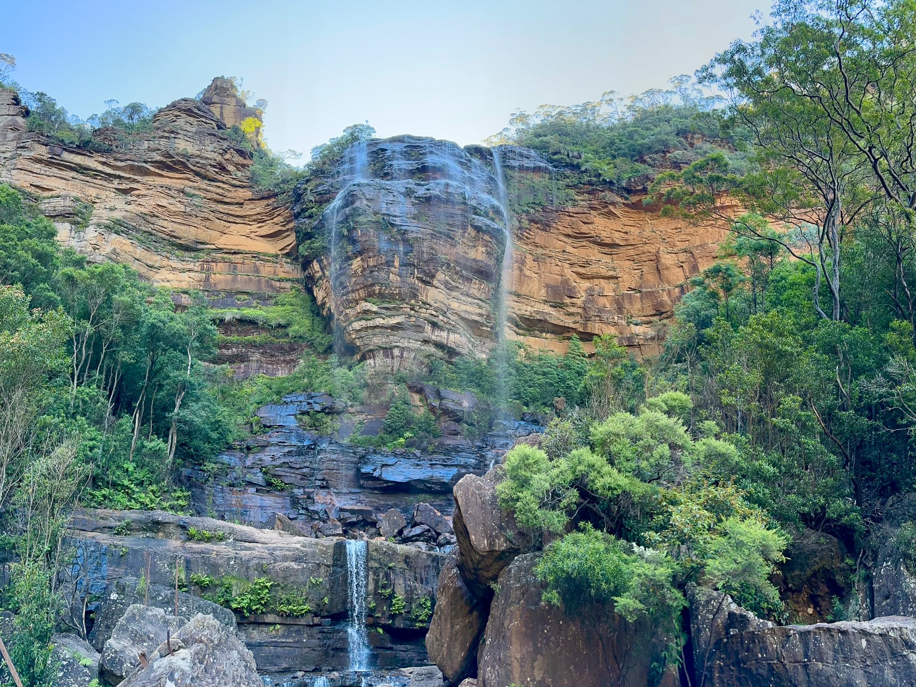 Majestic Wentworth Falls cascading down into the valley, surrounded by lush greenery and the beauty of the Blue Mountains.